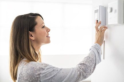 Woman setting the thermostat